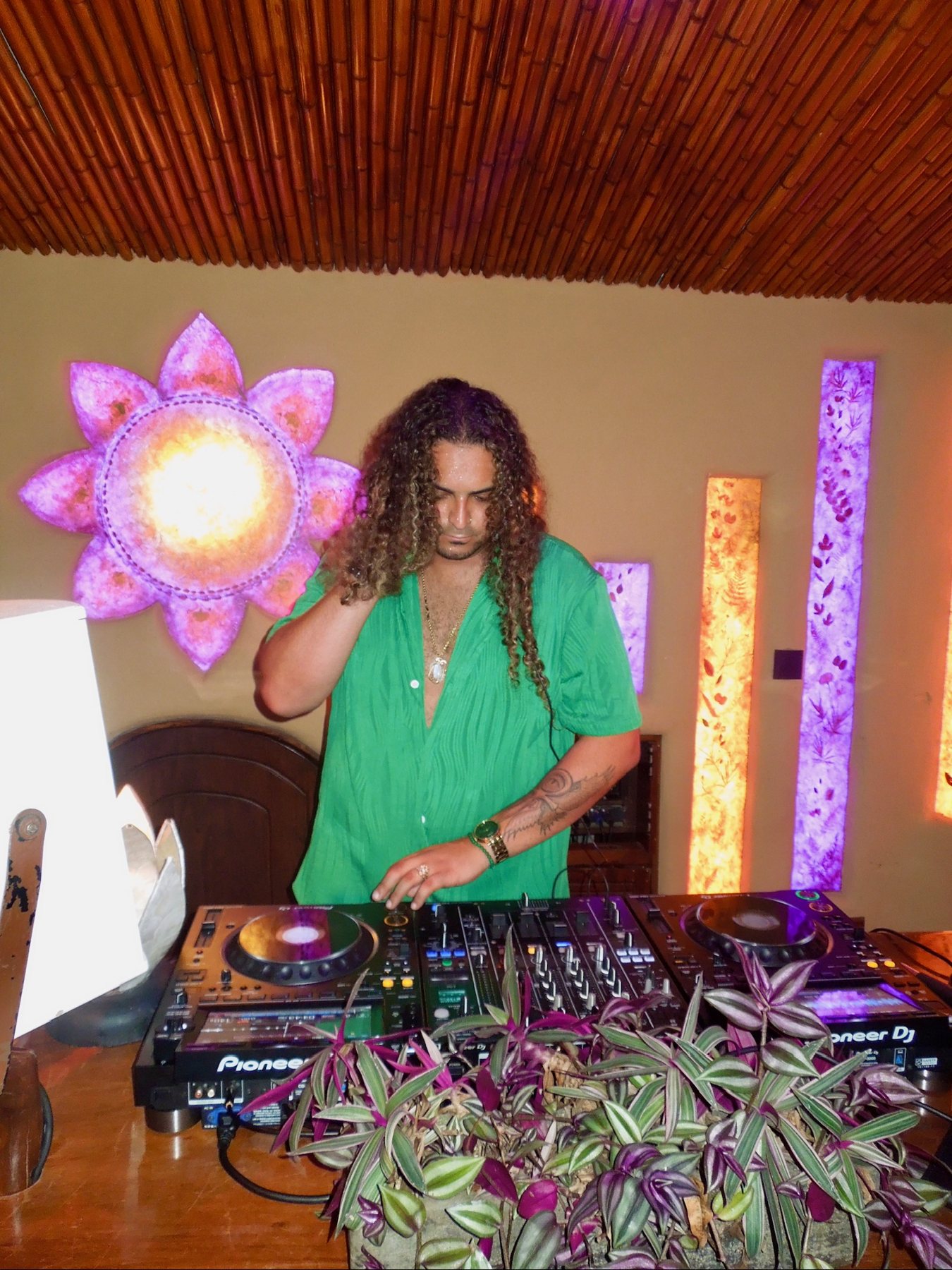 DJ playing at the bamboo bar under coloured light