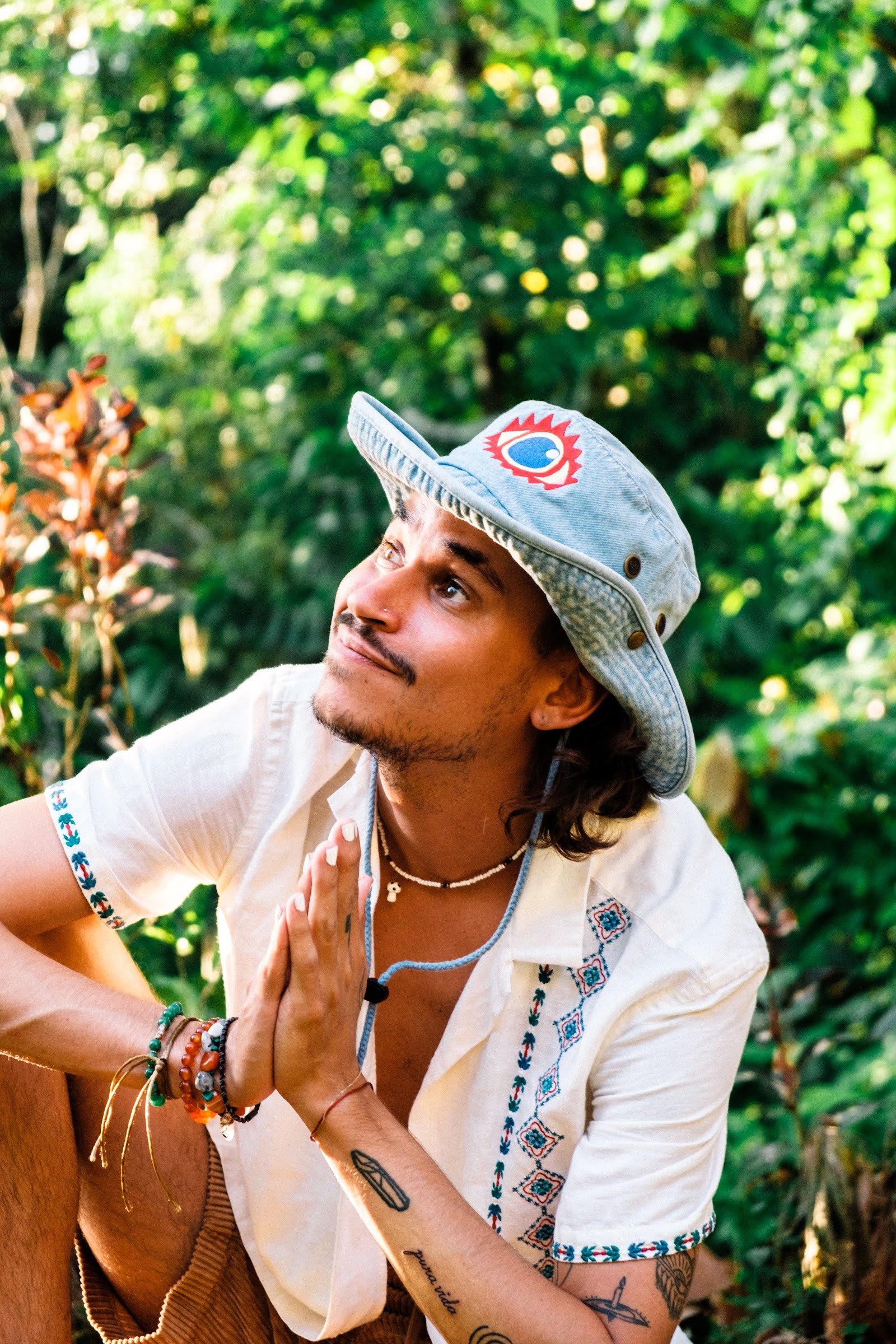 A guest sitting in the jungle with hands at his heart