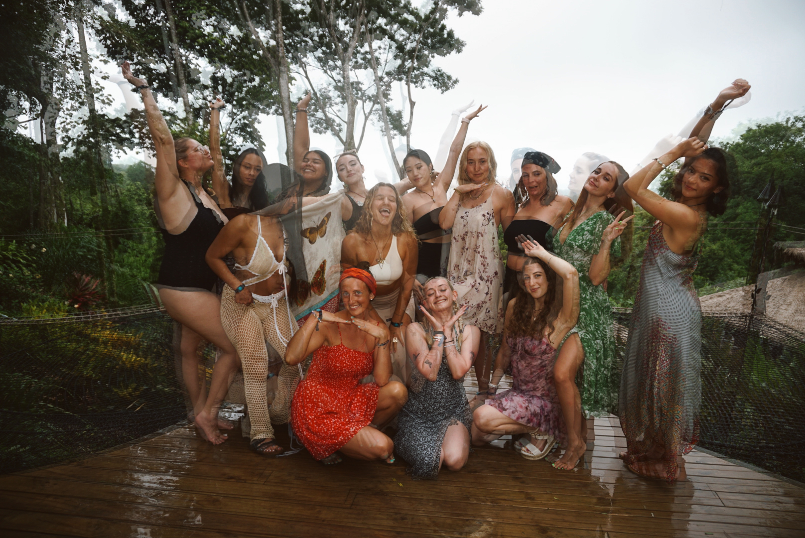 The whole retreat group posing together on the jungle canopy net in the rain
