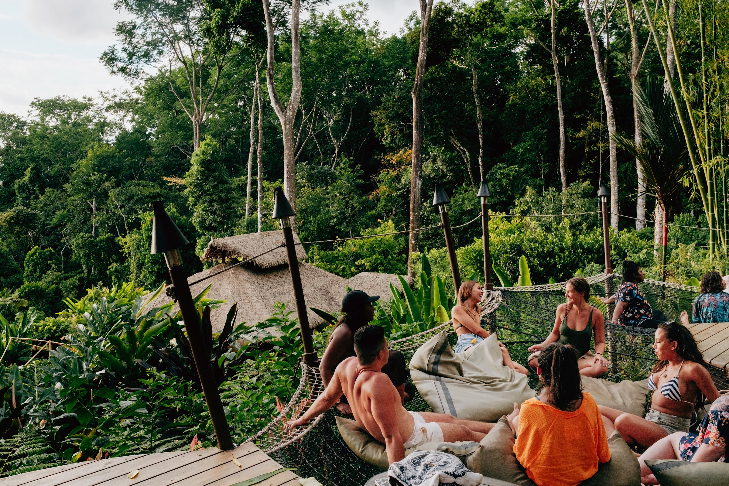 Circle gathered on cushions with the jungle behind