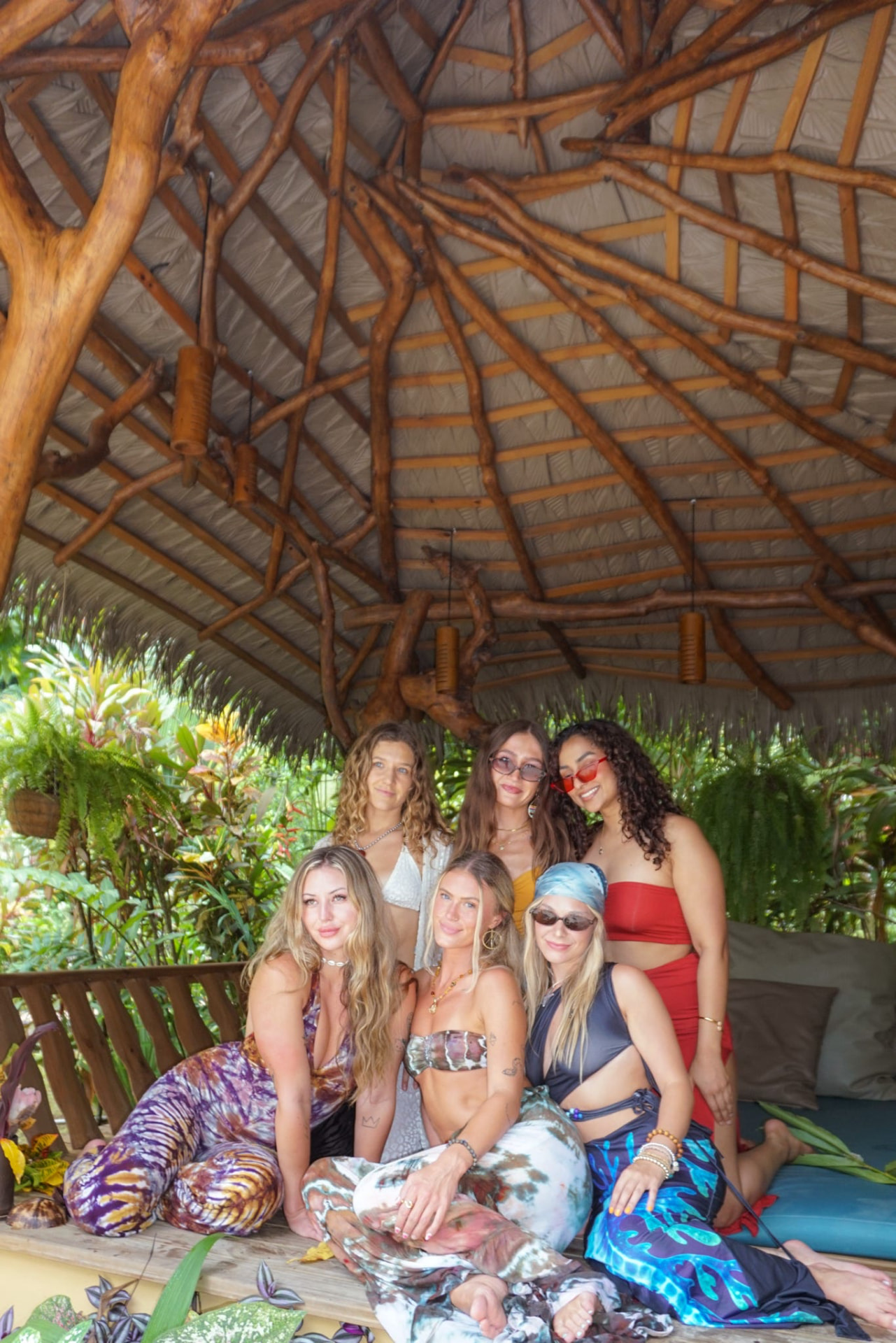 Six friends posing together under the jungle palapa