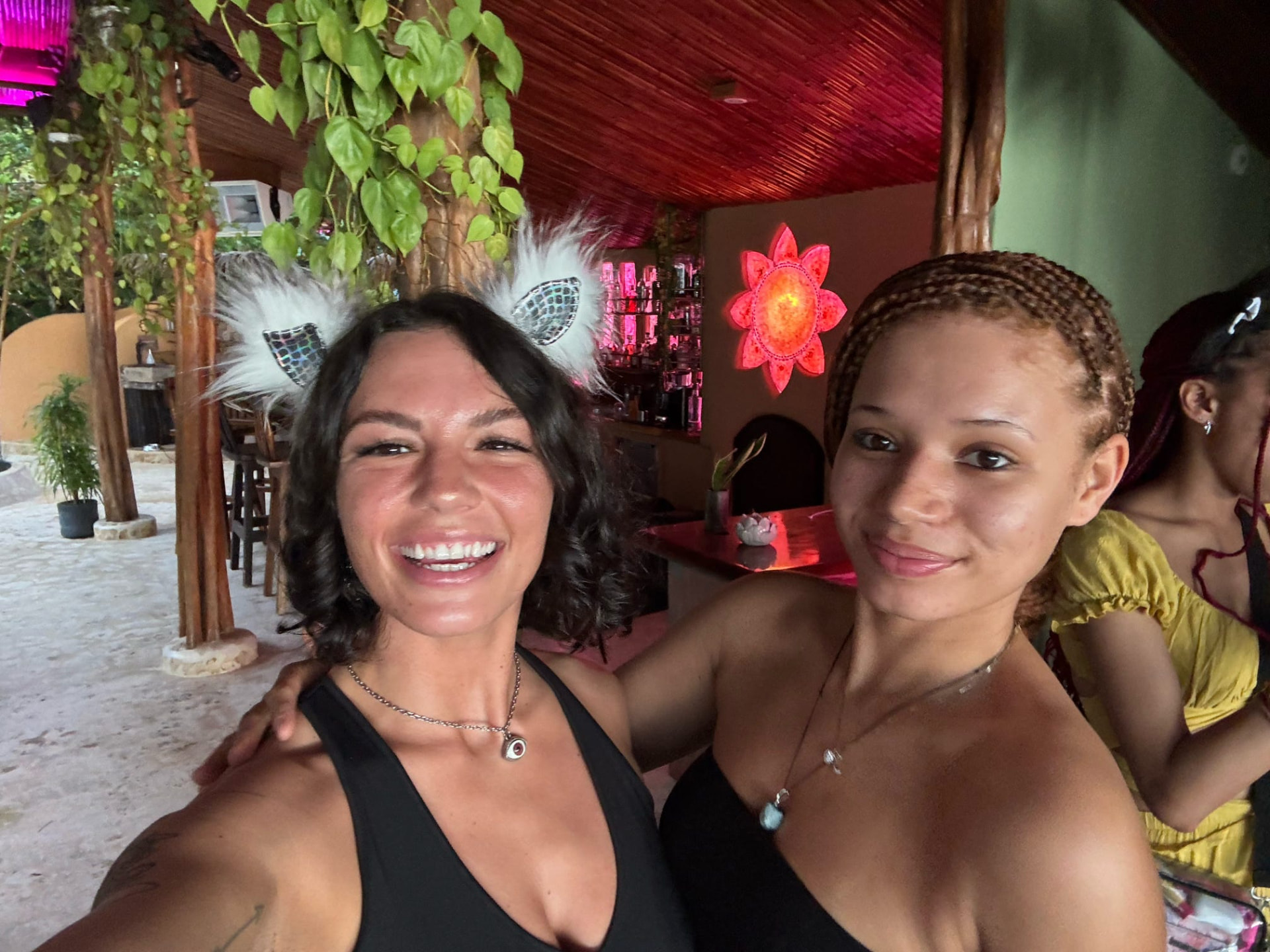 Selfie of two friends at the jungle bar with the glowing flower behind them