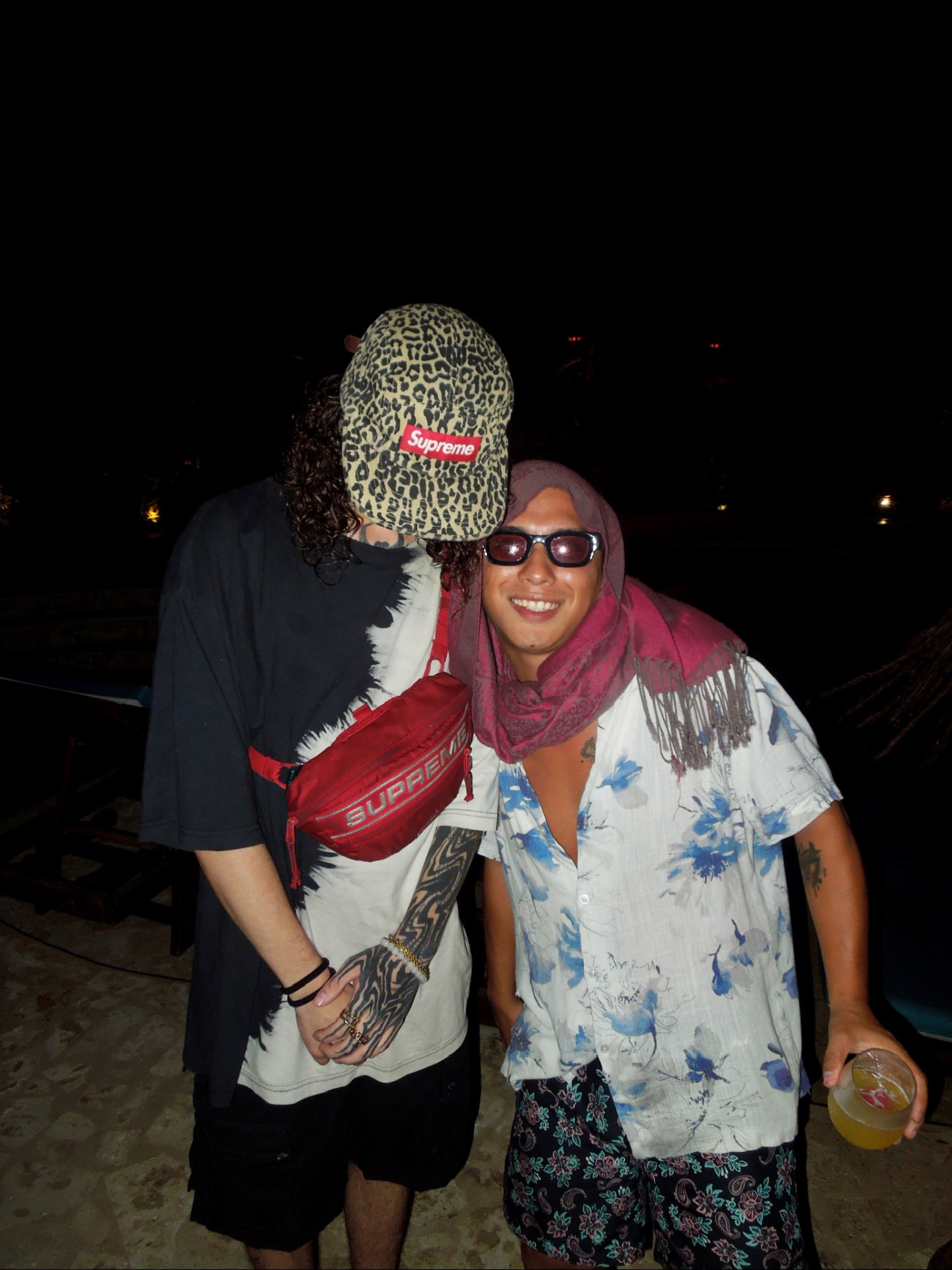 Two friends dressed up in full party fits at the jungle party at night