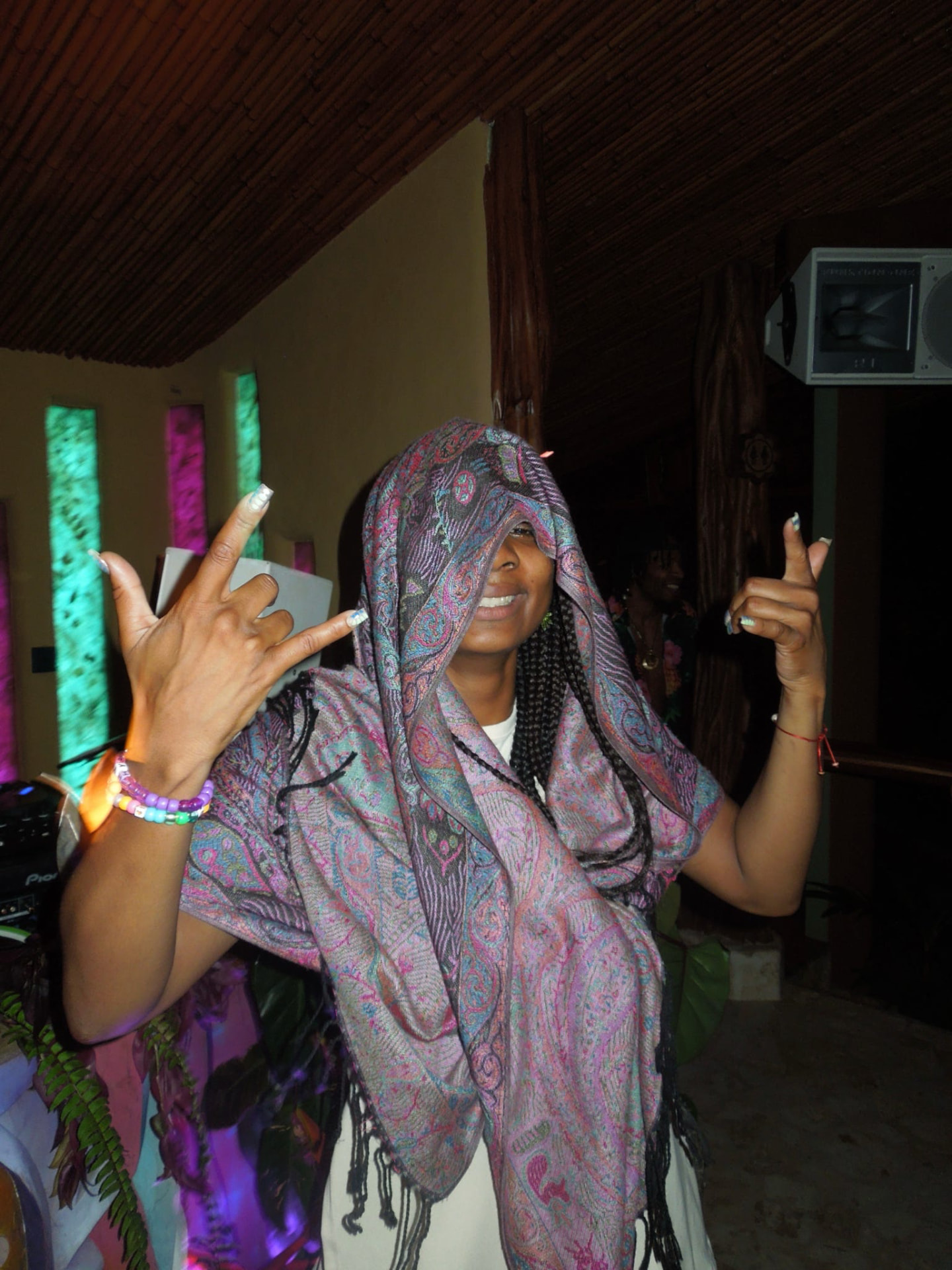 Throwing up rock hands in a pashmina by the DJ booth