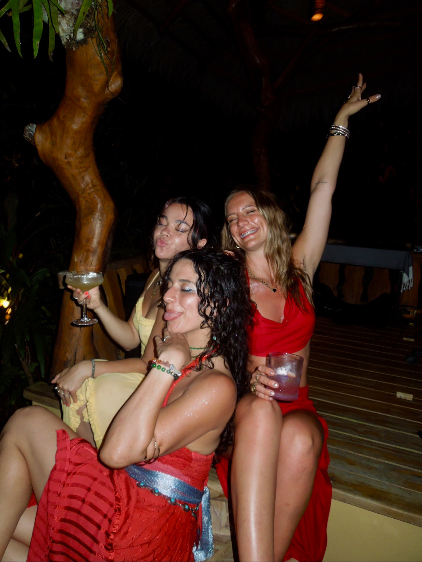 Three friends laughing together at the night party