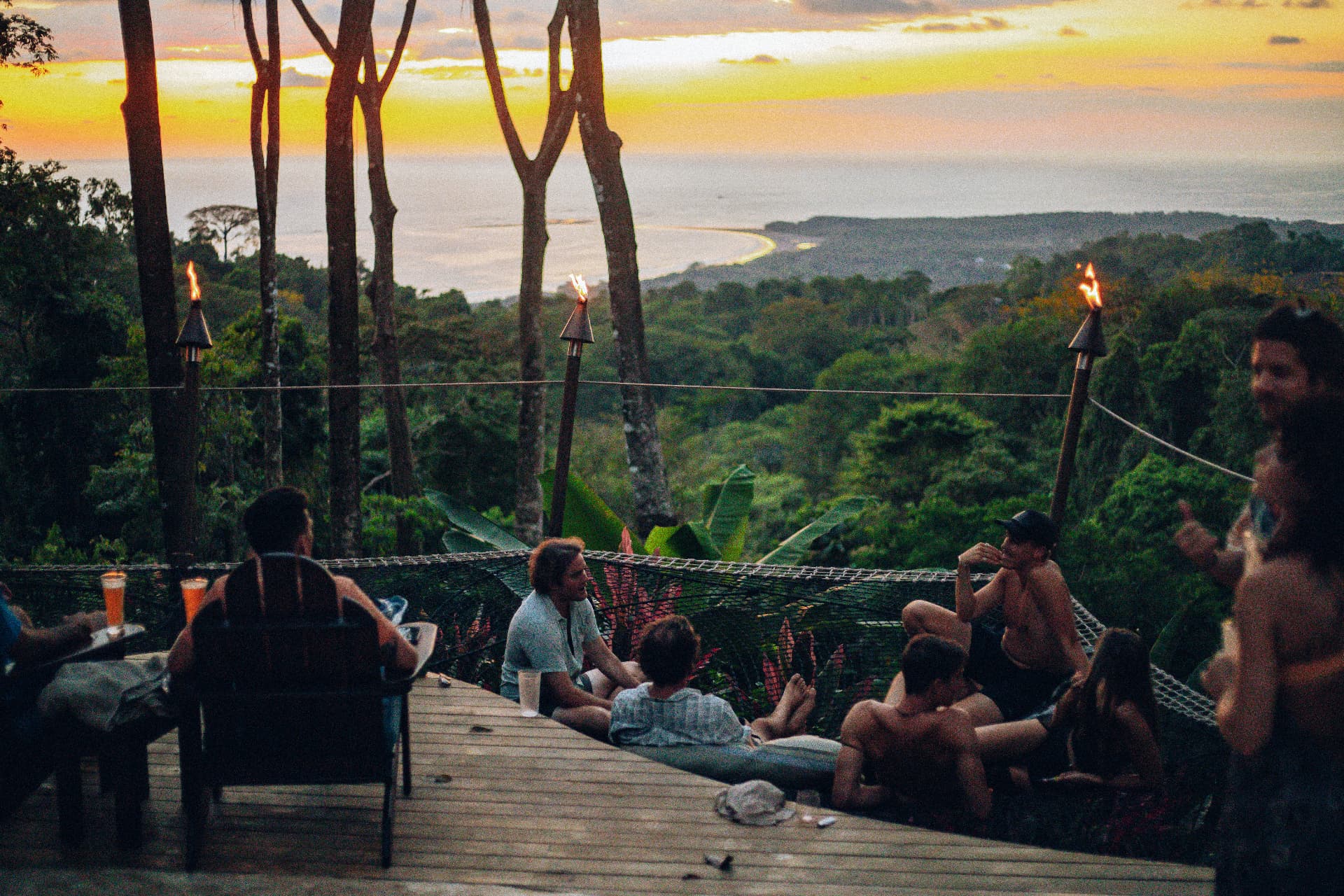 The crew hanging out together on the hammock net deck at sunset with torches lit