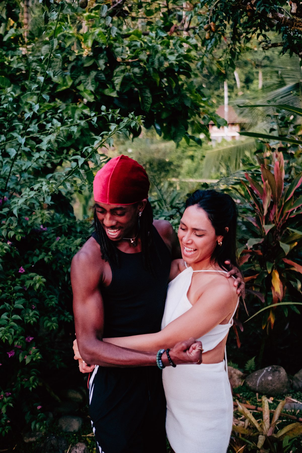 Two guests laughing together in the garden at golden hour