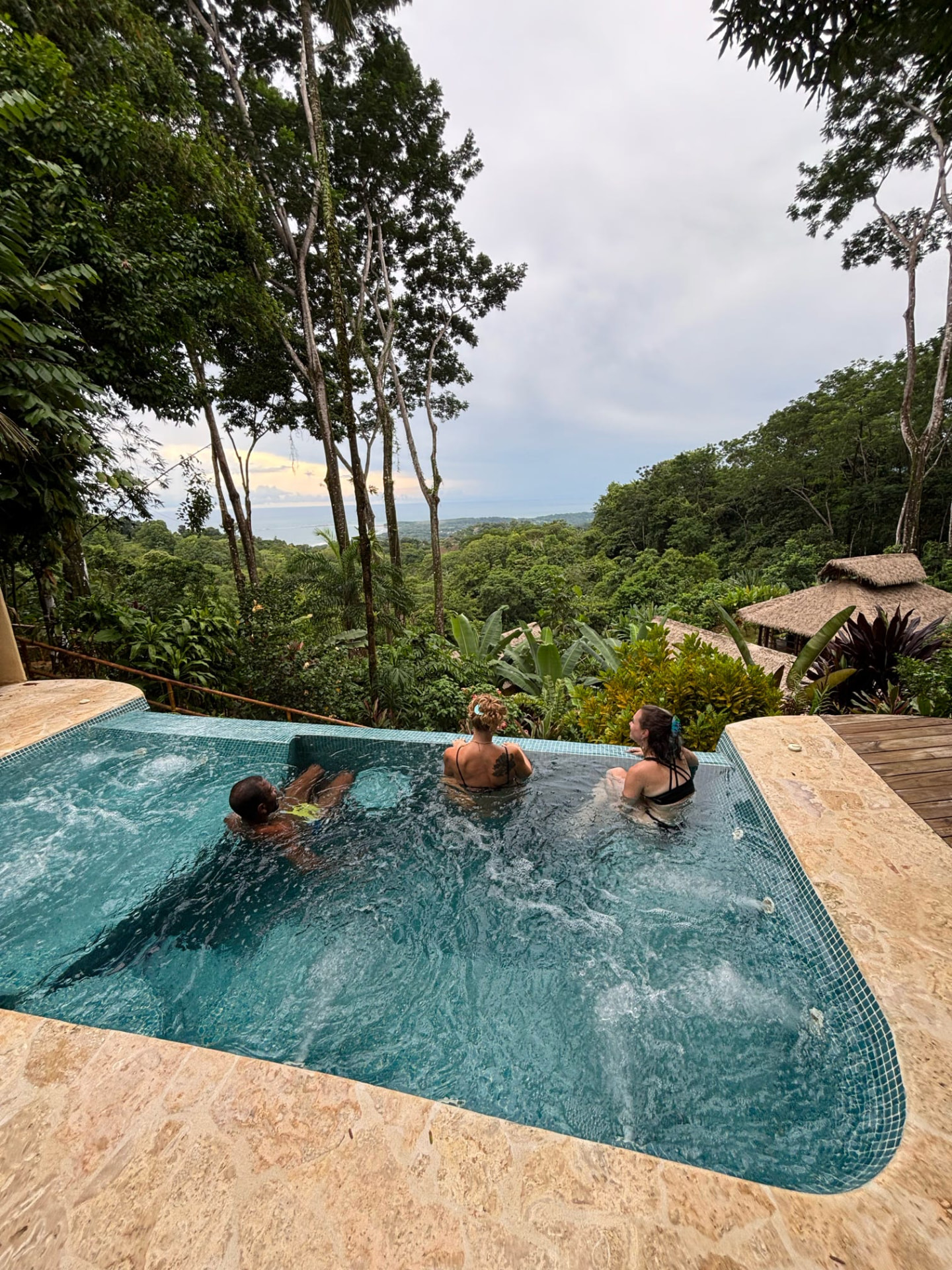 Friends in the plunge pool looking out over the jungle to the ocean
