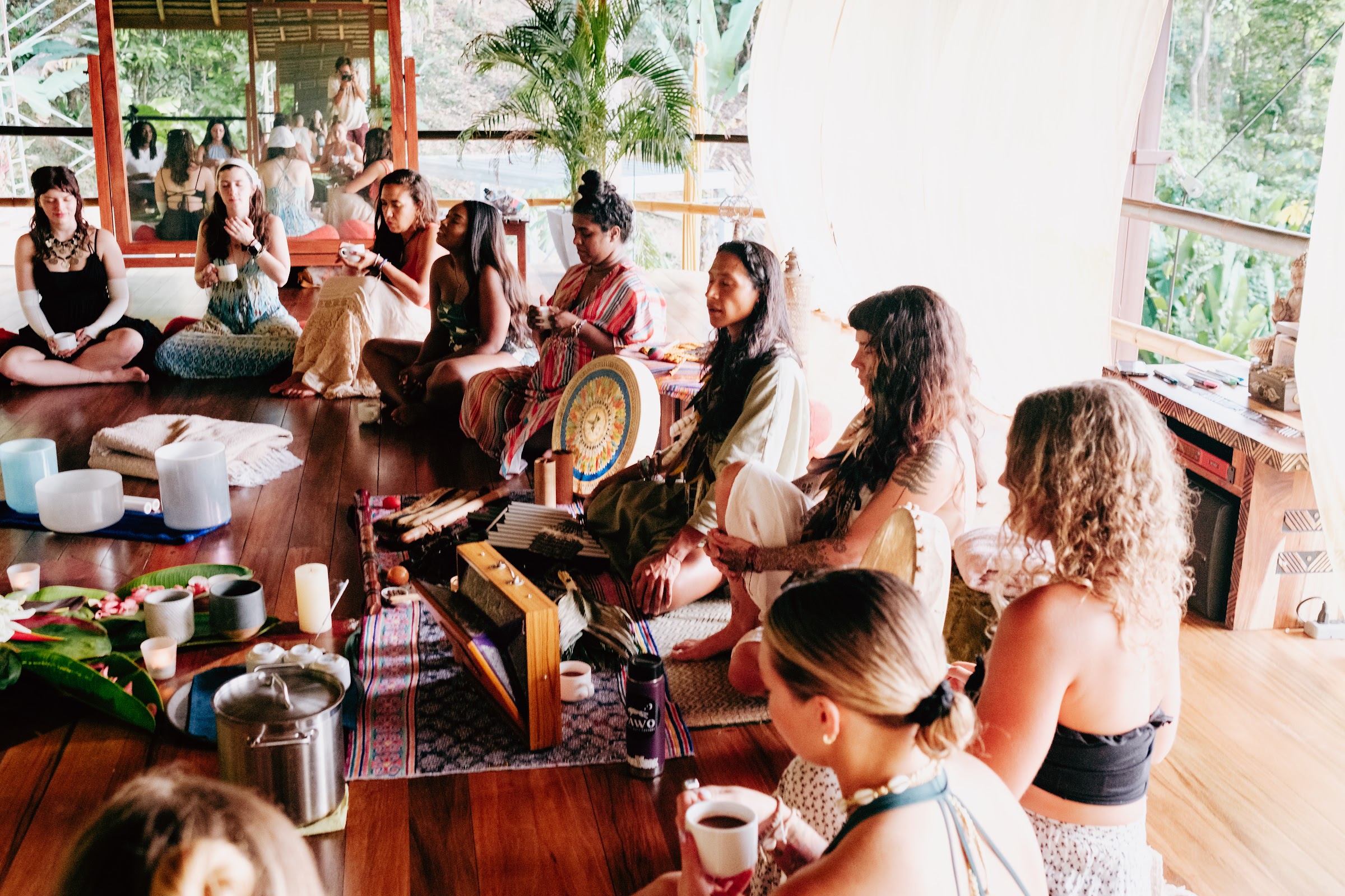 Cacao ceremony with singing bowls and the group holding warm cups
