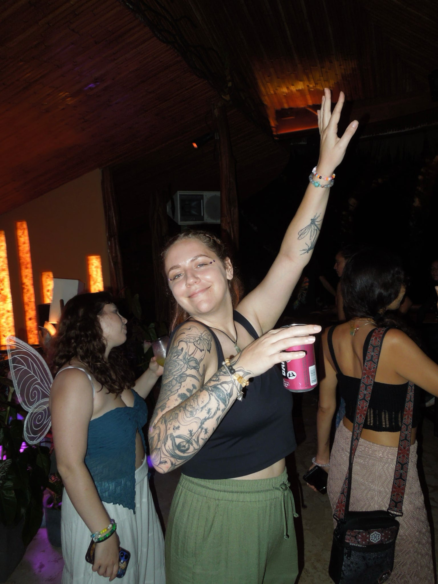 Friends dancing with arms up at the jungle party