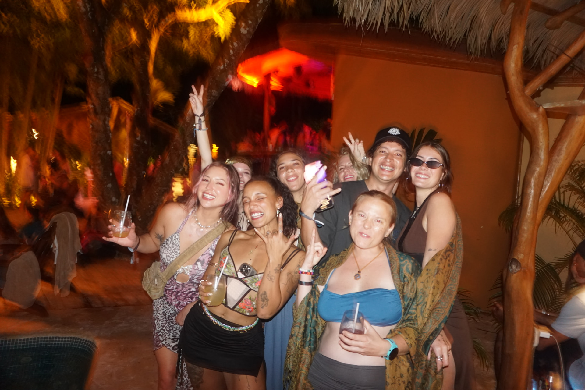 The crew crammed together by the pool bar throwing peace signs