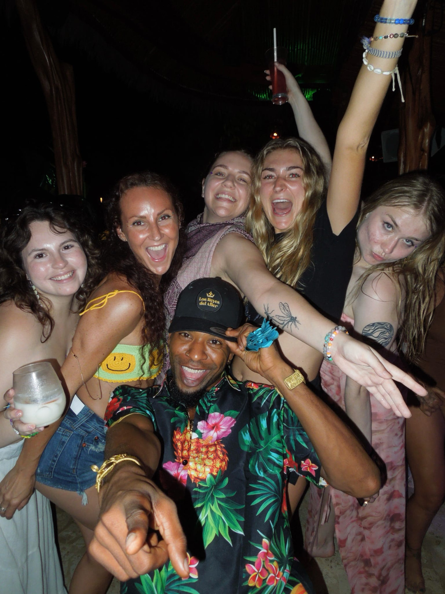 Group selfie at the jungle party with drinks and big smiles