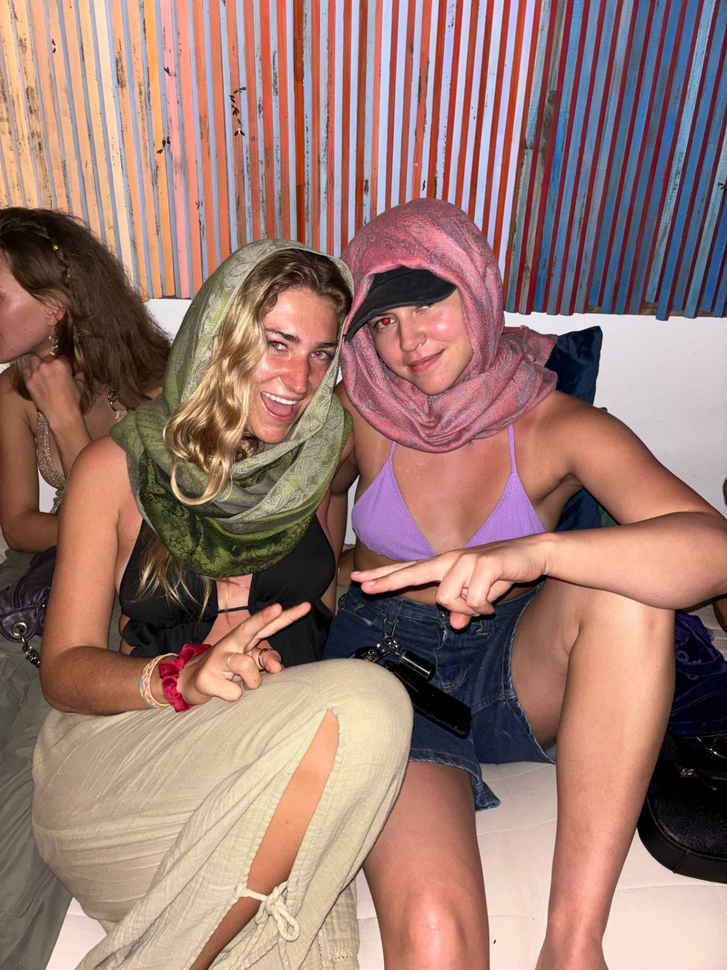 Two friends in scarf hoods lounging at the jungle bar