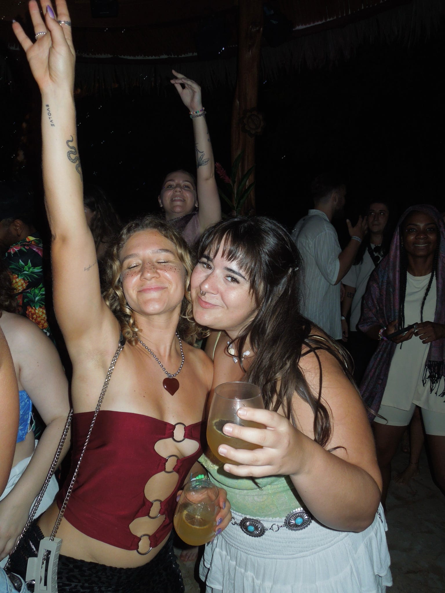 Two friends dancing with drinks in hand