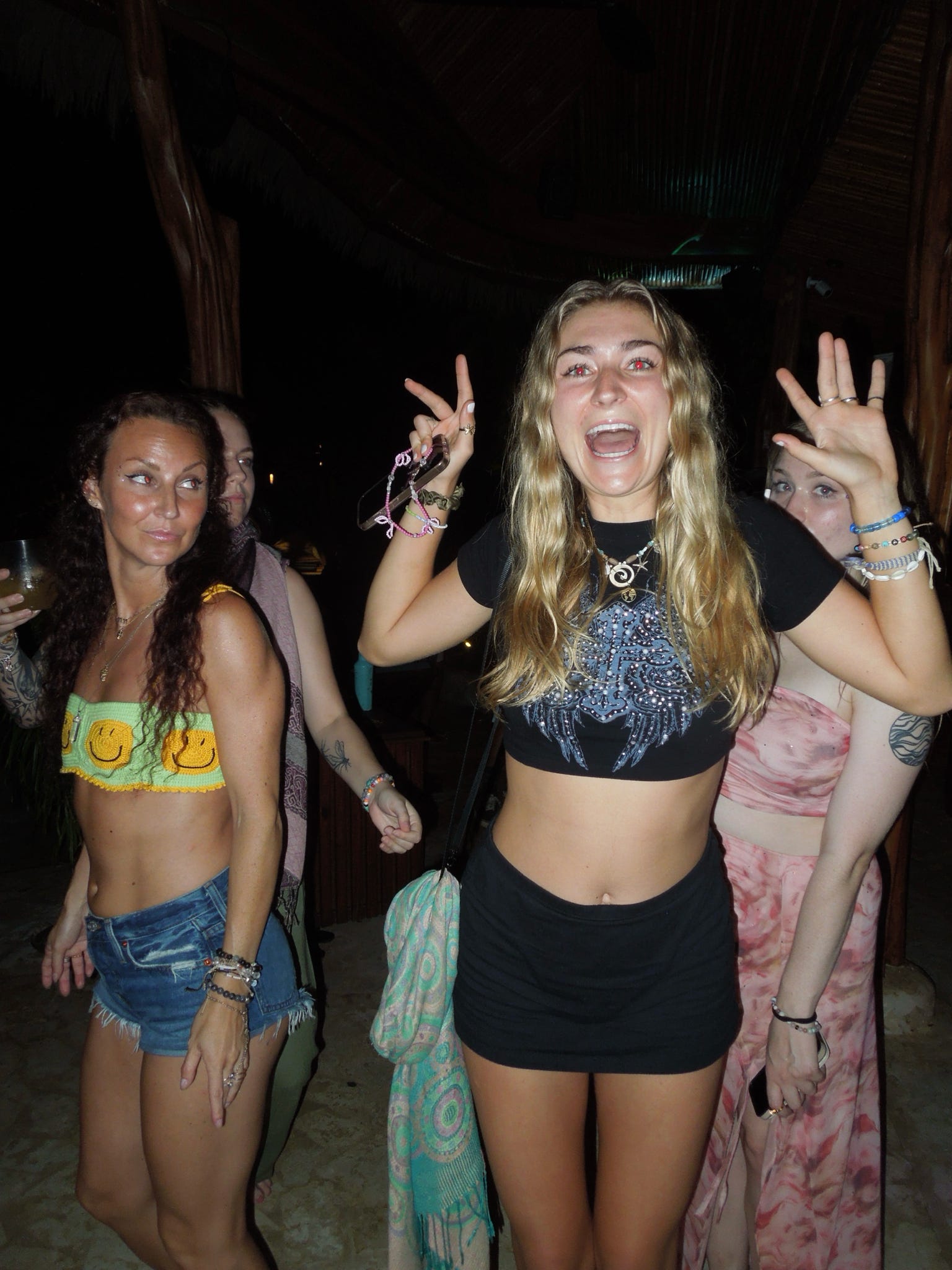 Three friends throwing peace signs on the dancefloor