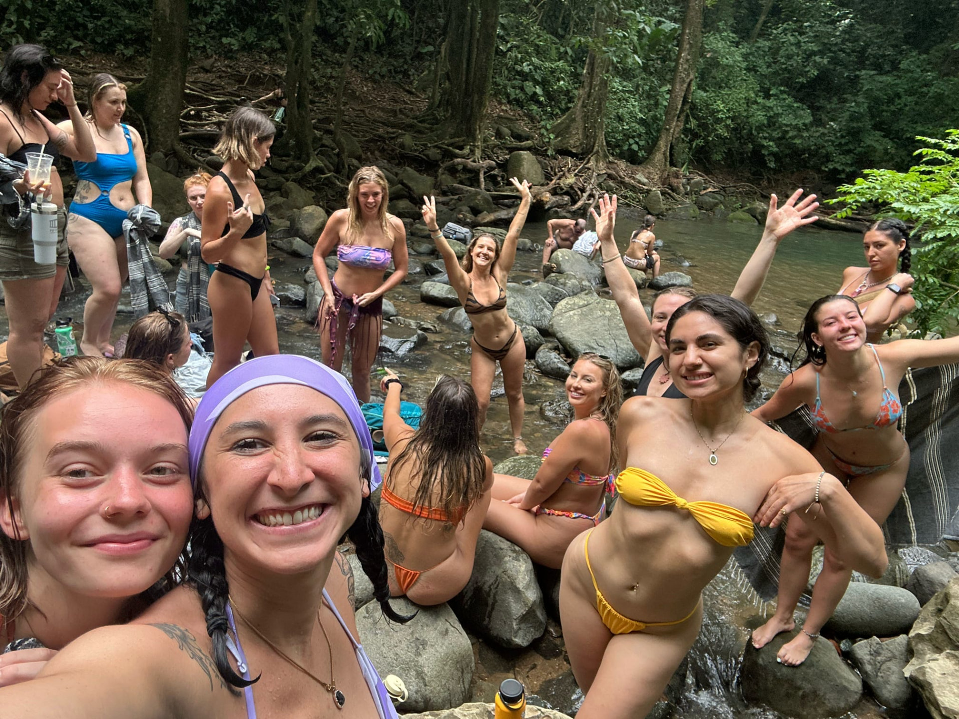 Retreat group taking a joyful selfie beside the jungle river