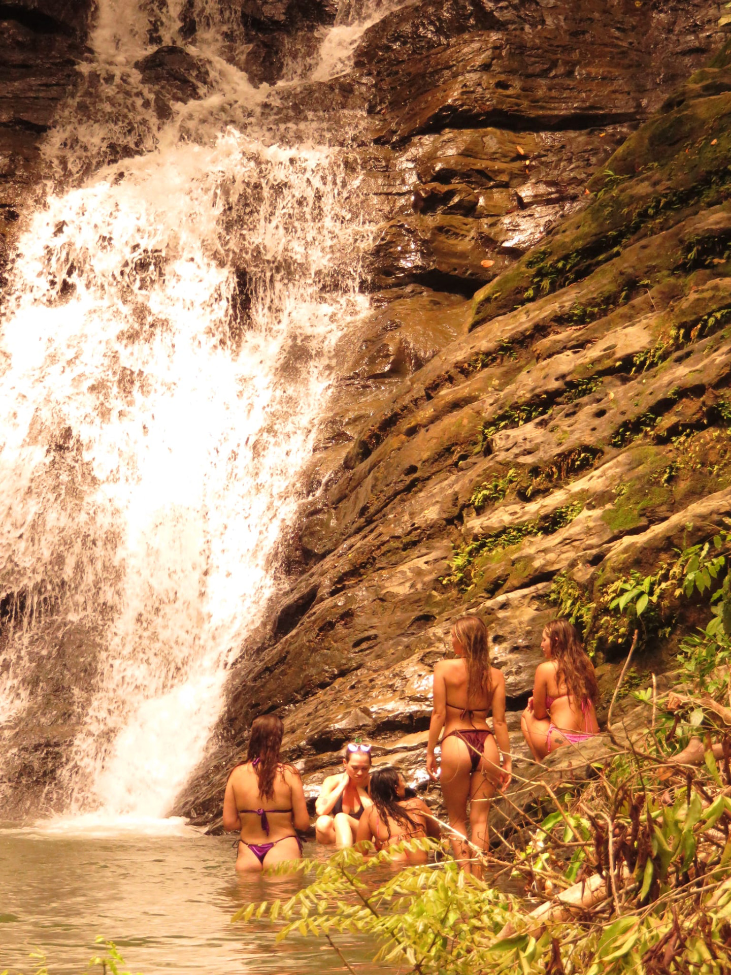The crew gathered at the base of the waterfall in golden light