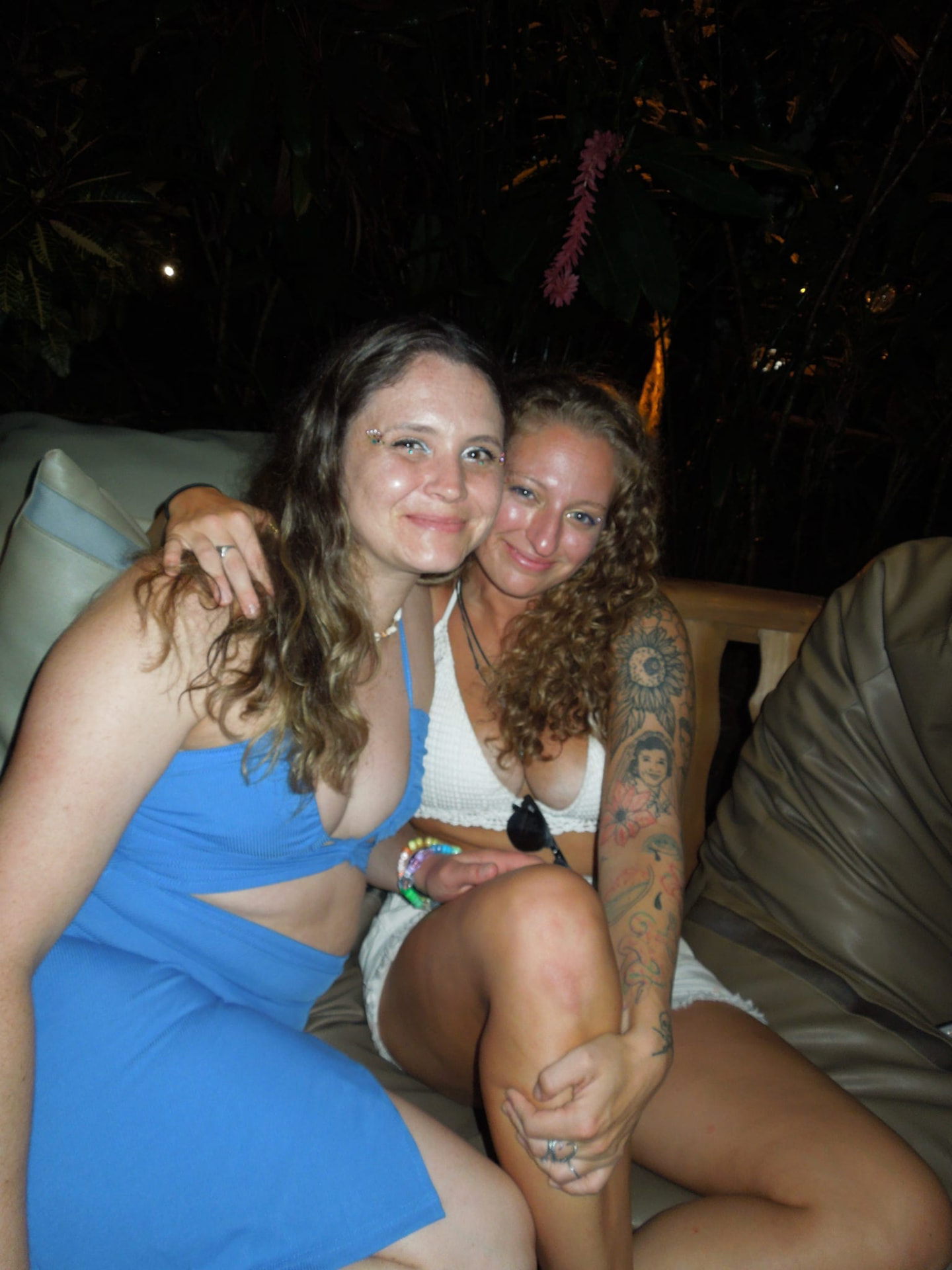 Two friends hugging on the lounge sofa in the jungle at night