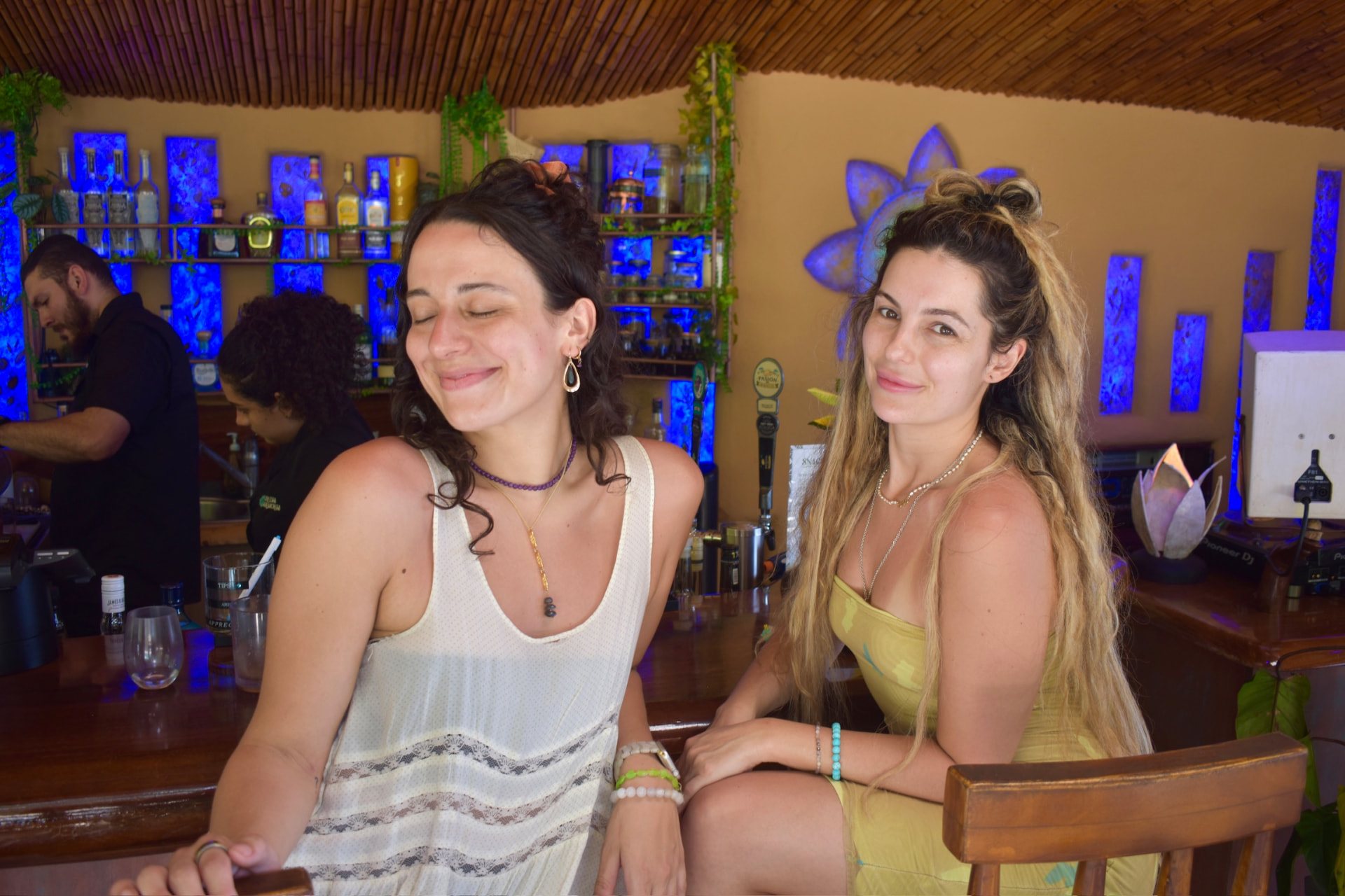 Two friends laughing together at the bamboo bar