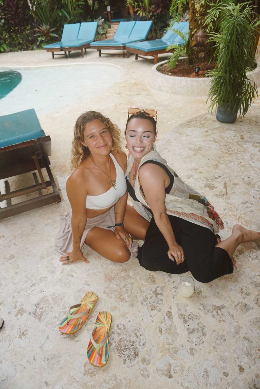 Two friends sitting together beside the jungle pool