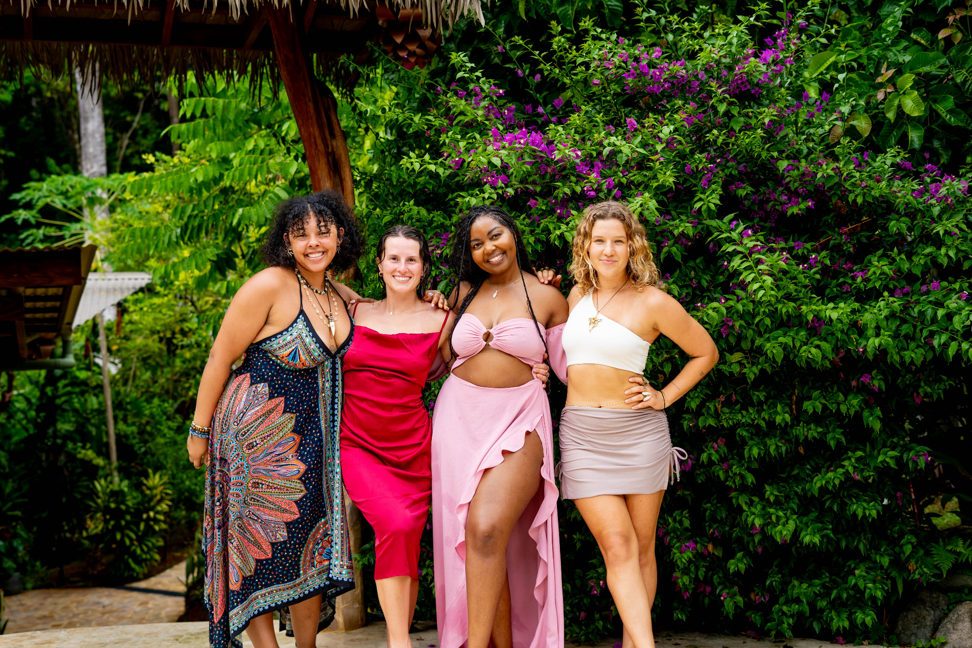 Four friends dressed up together by the bougainvillea before dinner