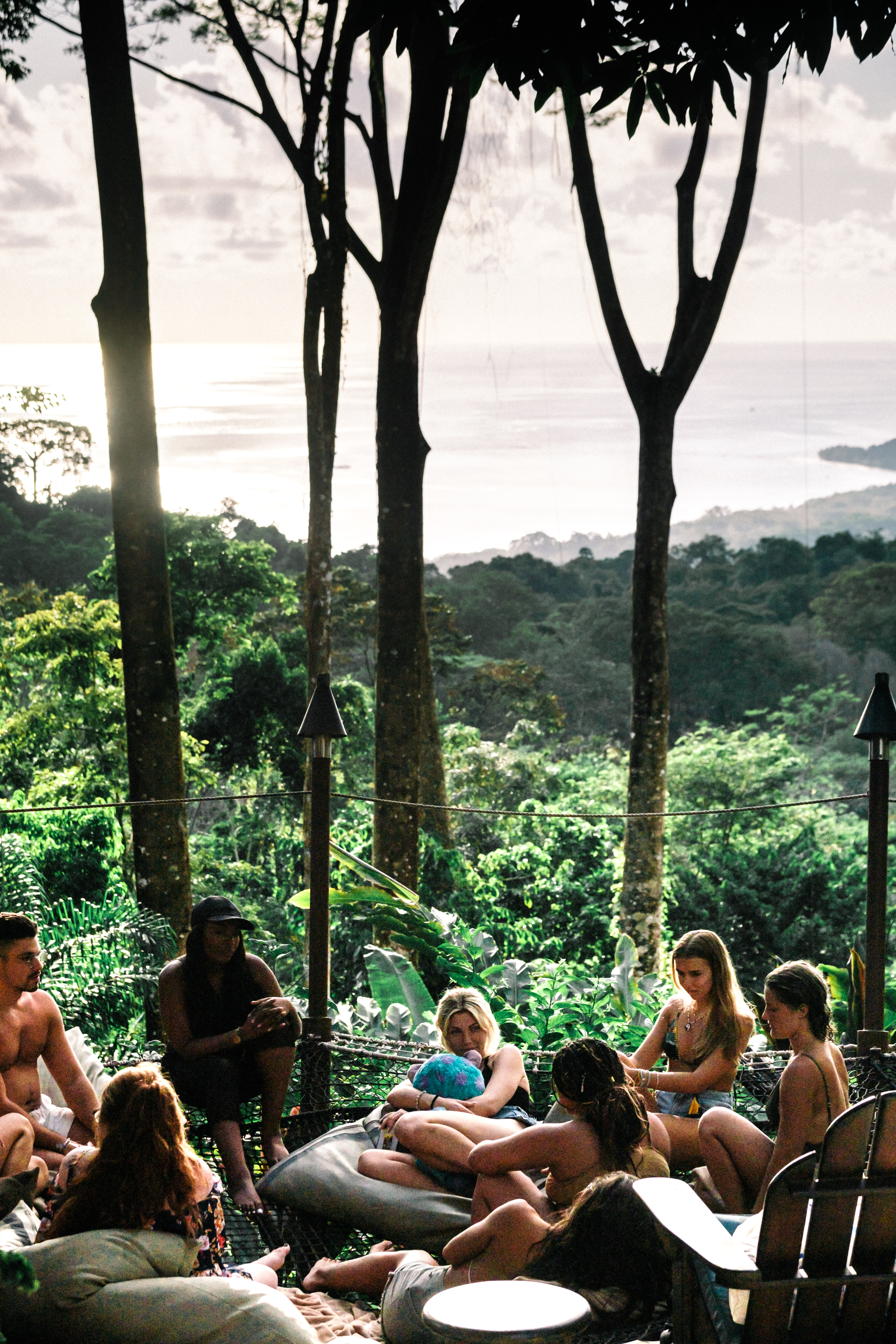 Group gathered on cushions with the ocean view behind