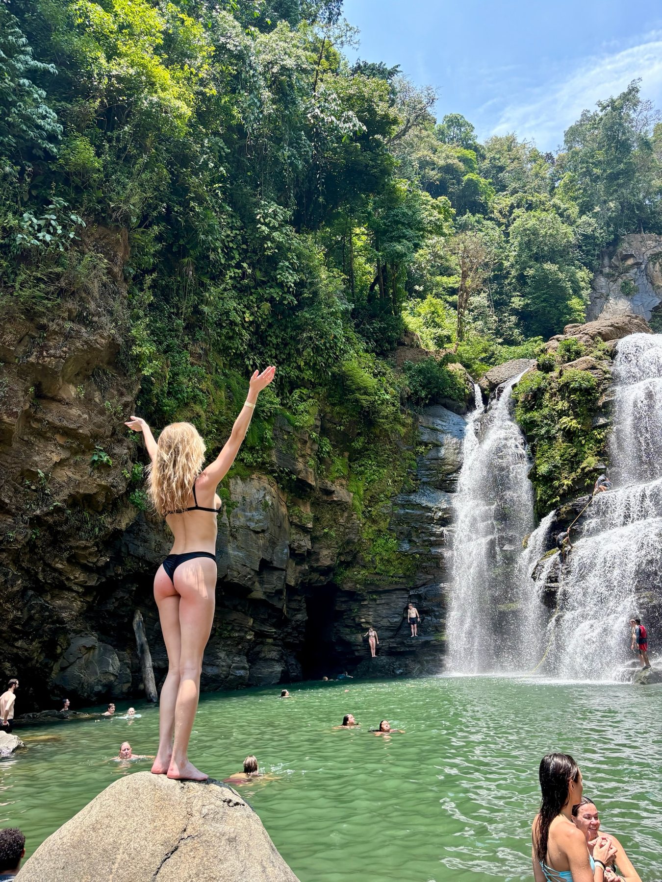 Standing at the edge of the waterfall pool