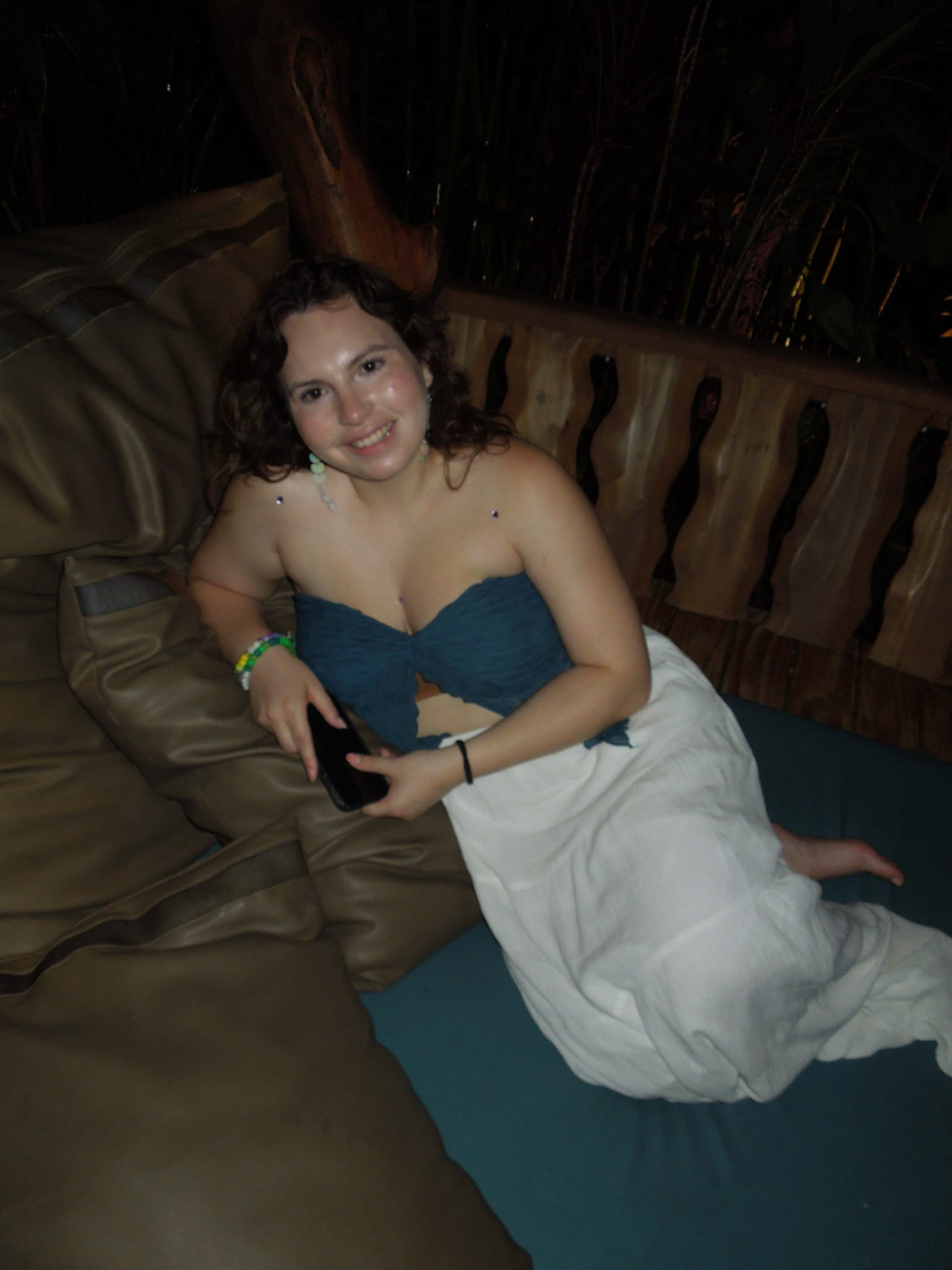 A guest relaxing on the daybed at the palapa bar at night