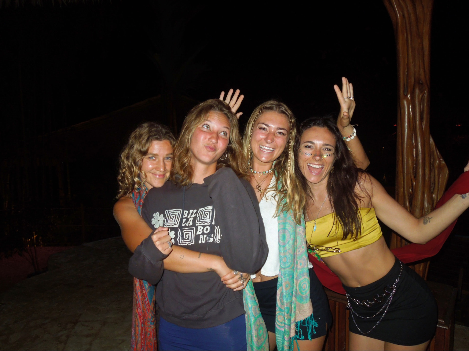 Four friends posing together at the party