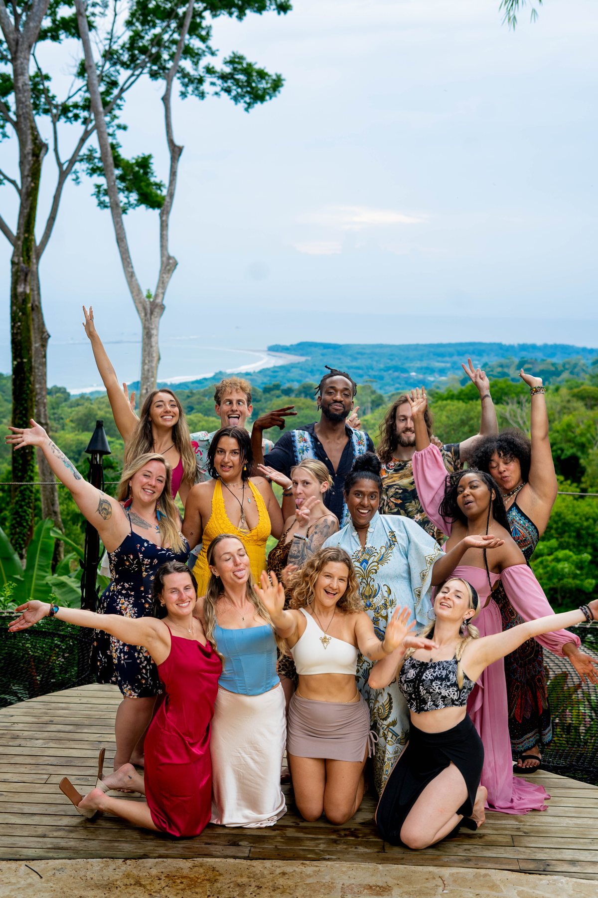 The whole crew throwing their arms up together over the jungle valley