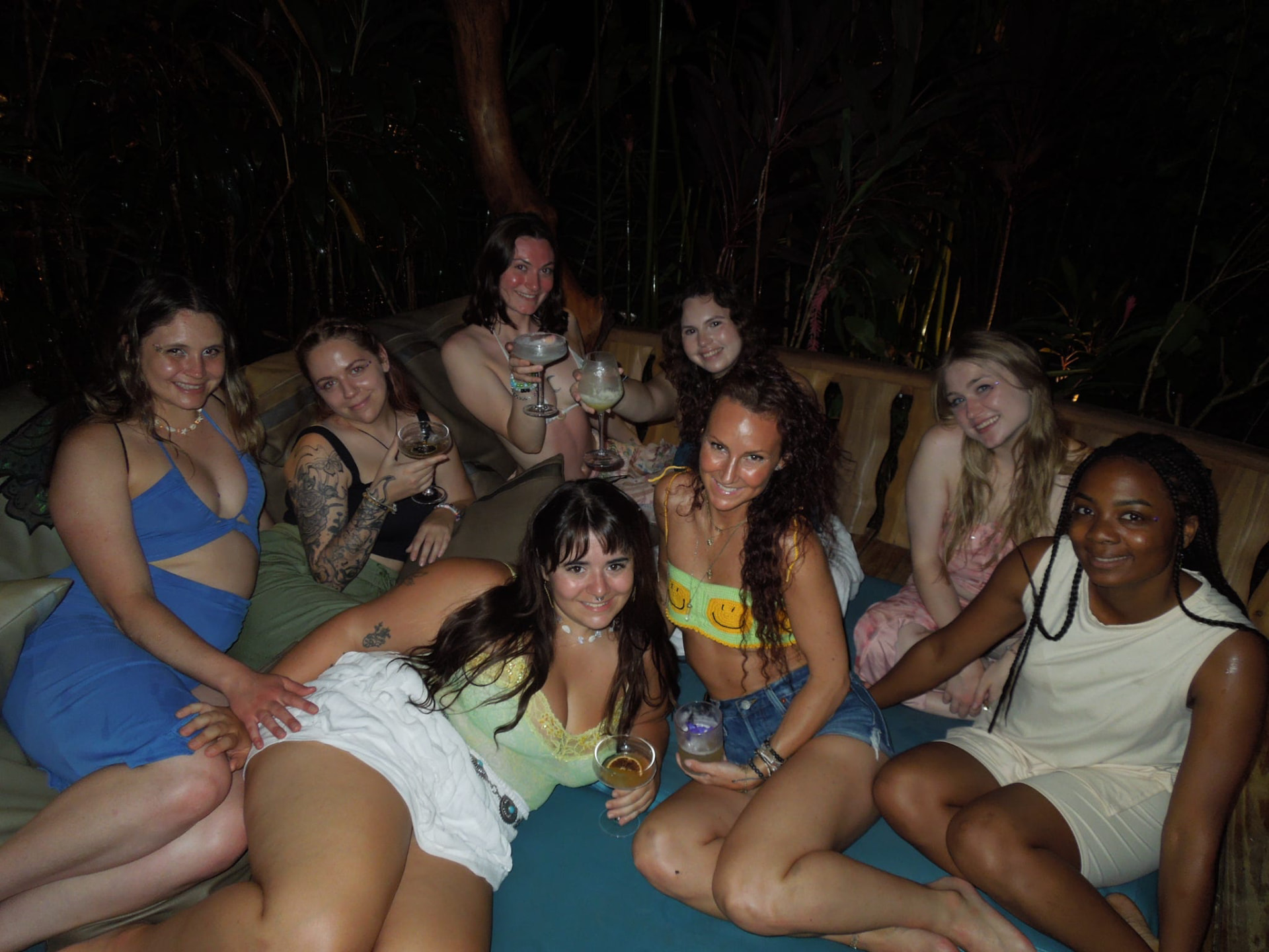 The crew piled onto the jungle daybed with drinks at night