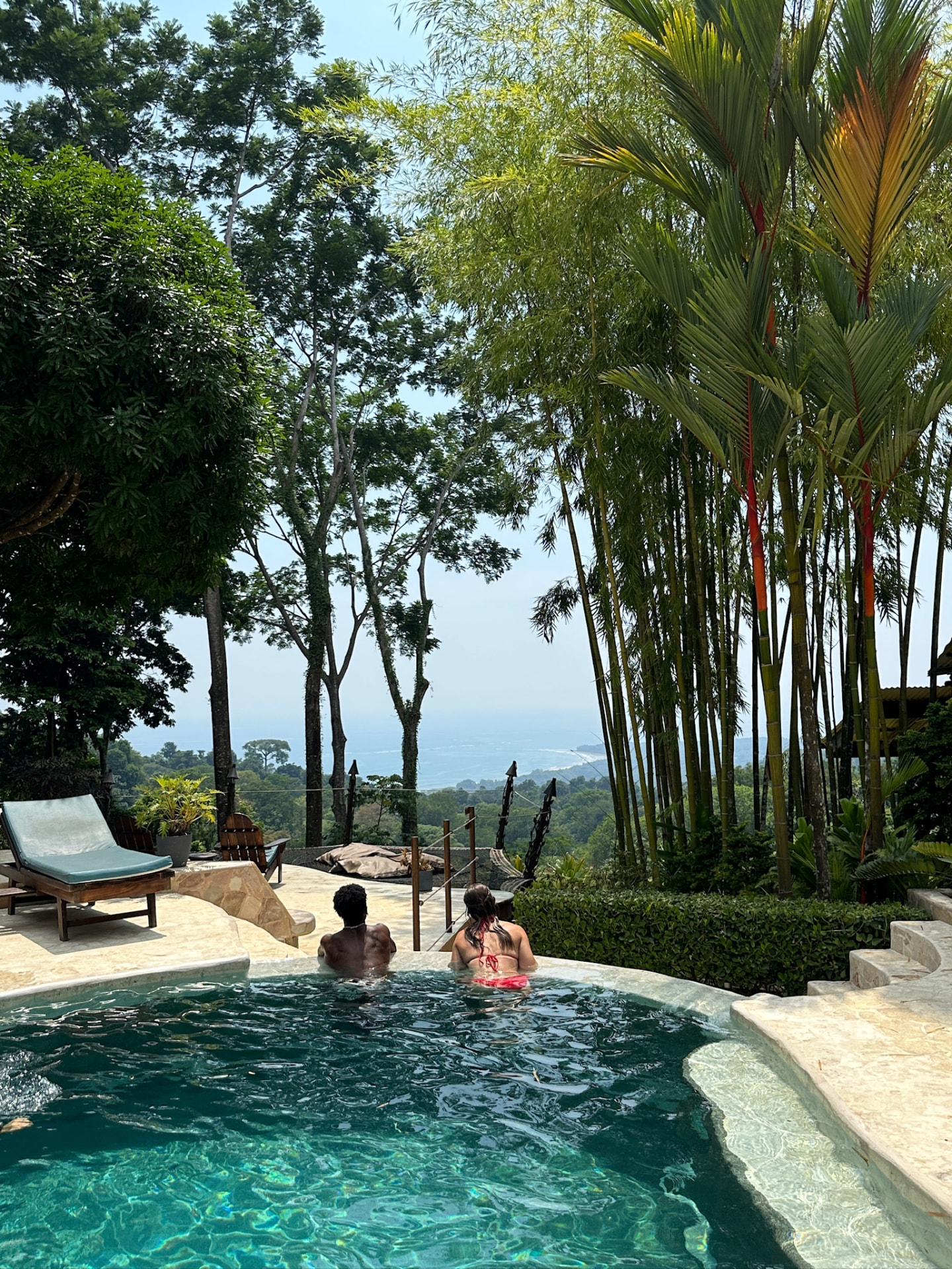 Two retreat guests in the infinity pool looking out to the ocean