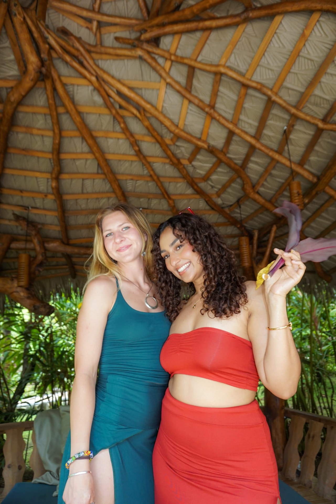 Two friends in teal and red posing under the palapa