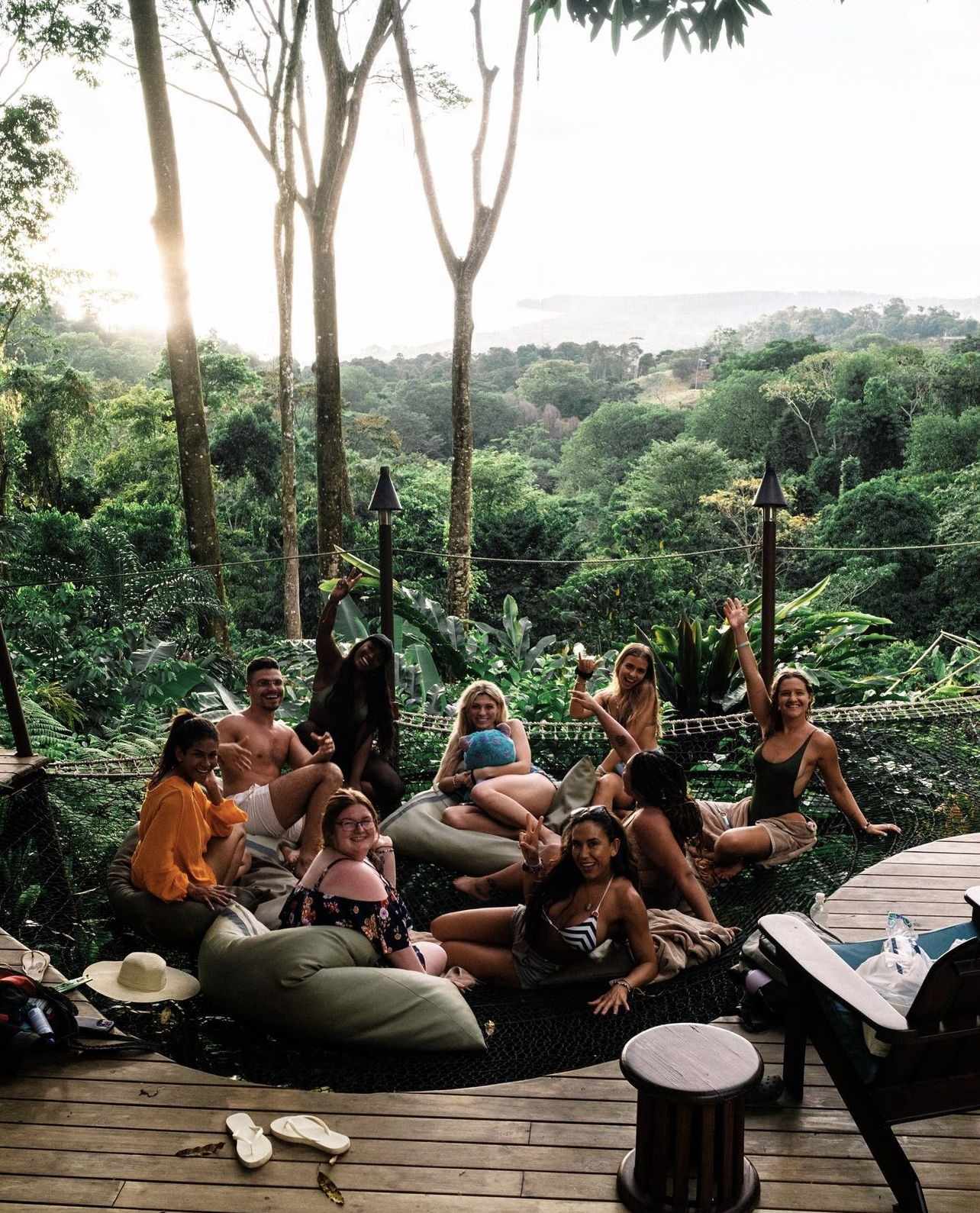 The crew lounging on the hammock net deck above the jungle canopy with the ocean in the distance