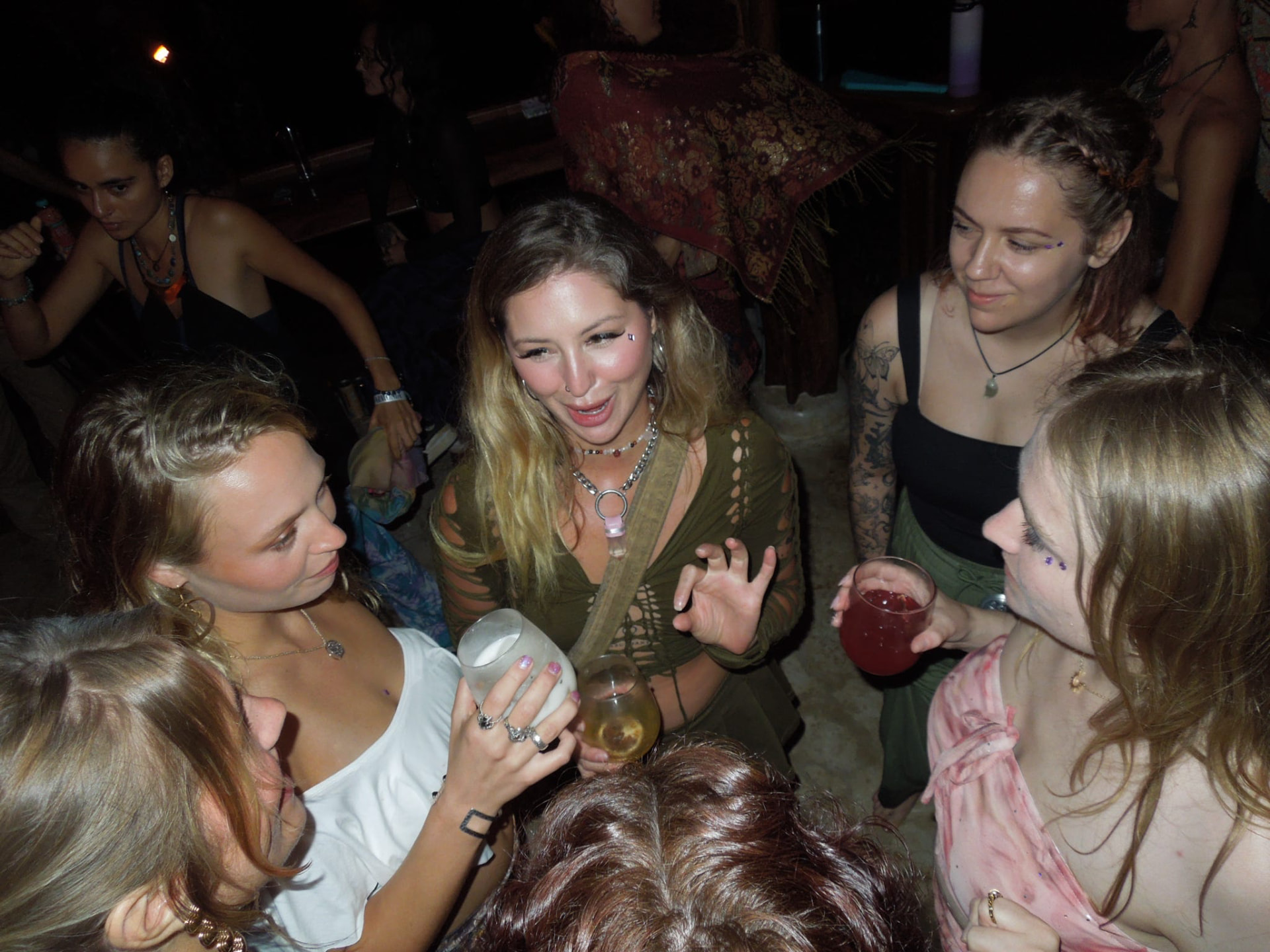 Friends gathered close with cocktails on the dance floor at night
