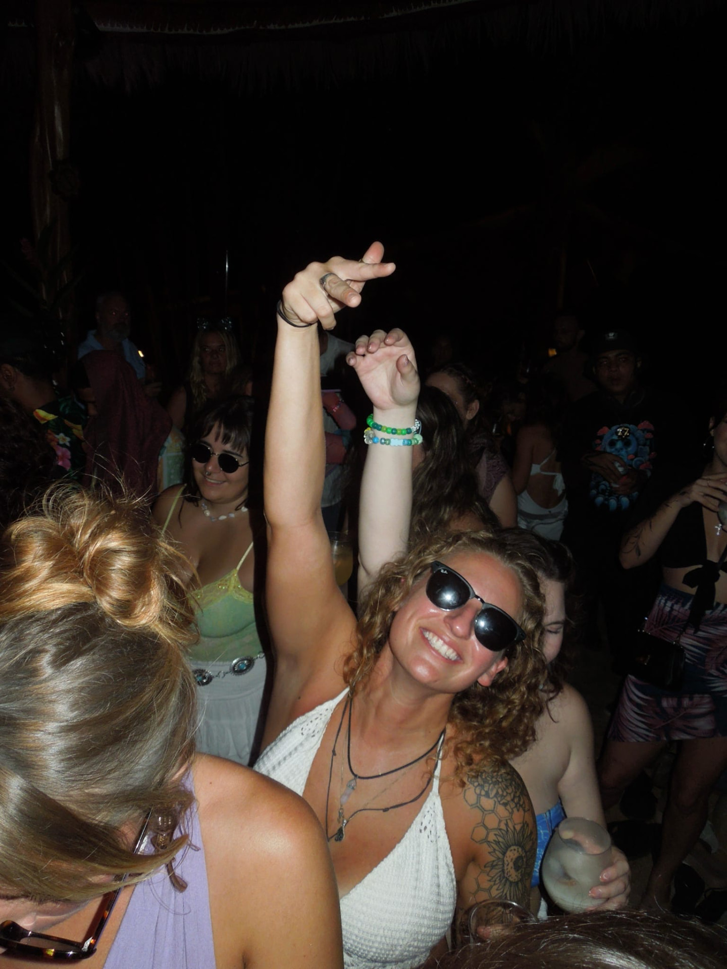 Arms up on the dancefloor in sunglasses