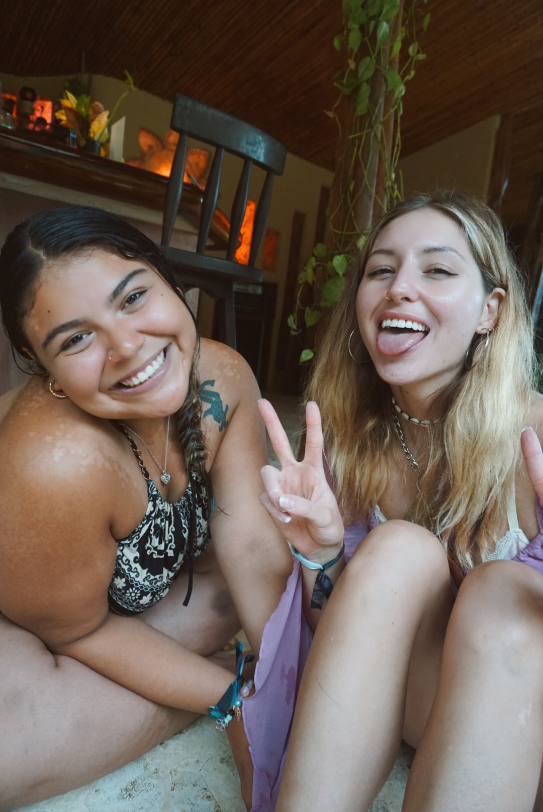 Two friends making peace signs and laughing in the shala