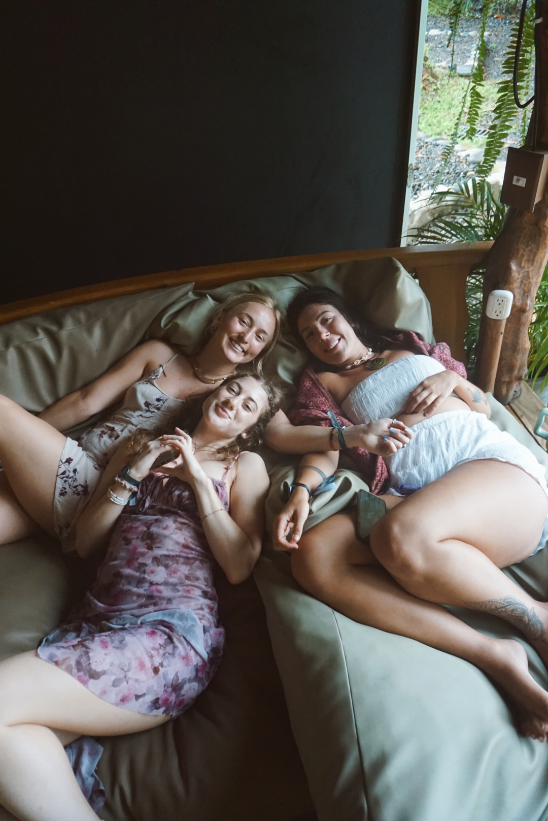 Three friends relaxing together on a jungle daybed