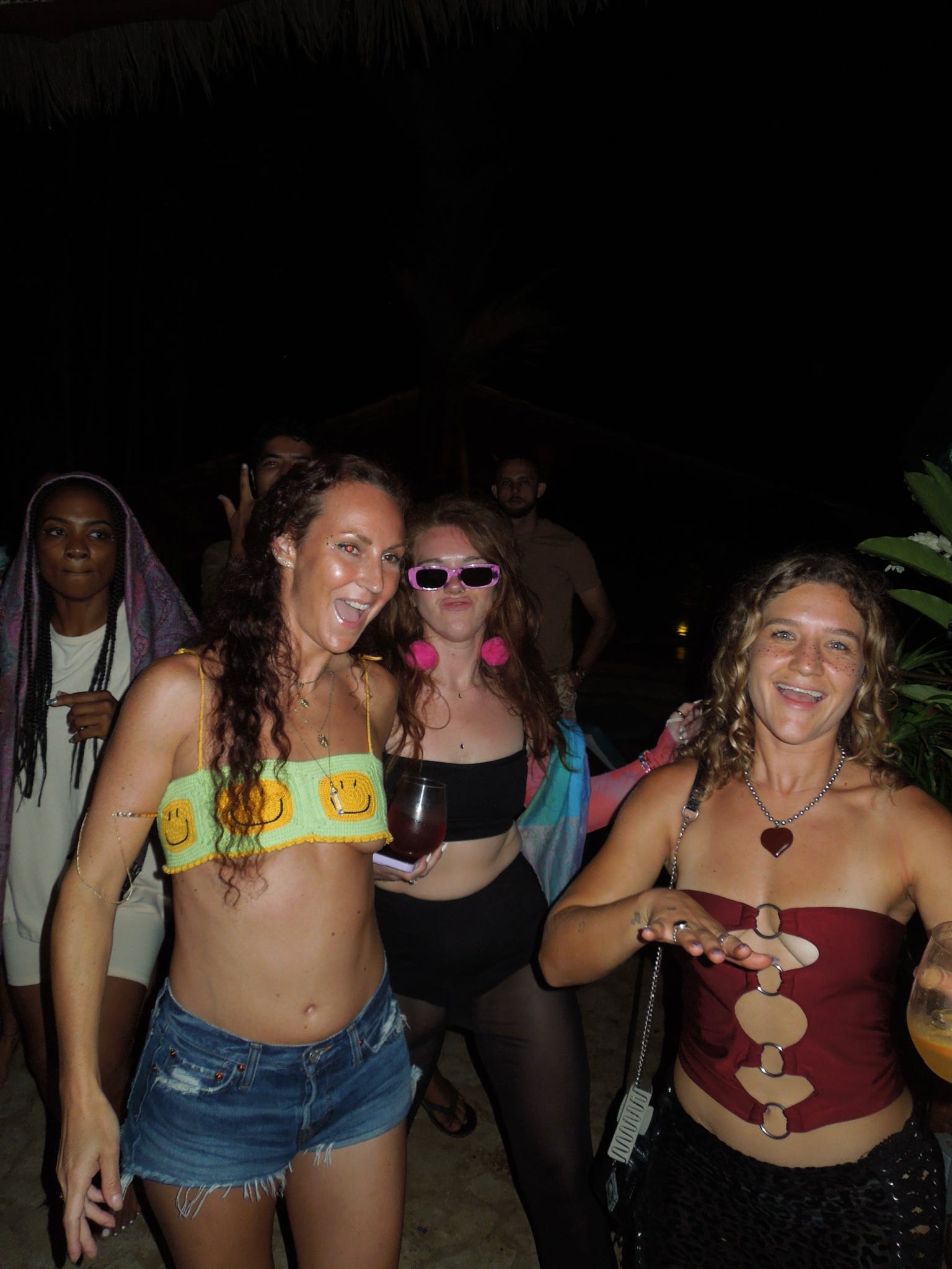 Three friends dancing together outdoors at night