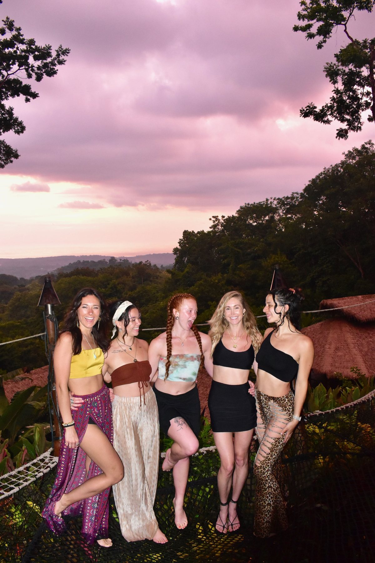 Friends on the hammock nets as the sun sets pink over the jungle