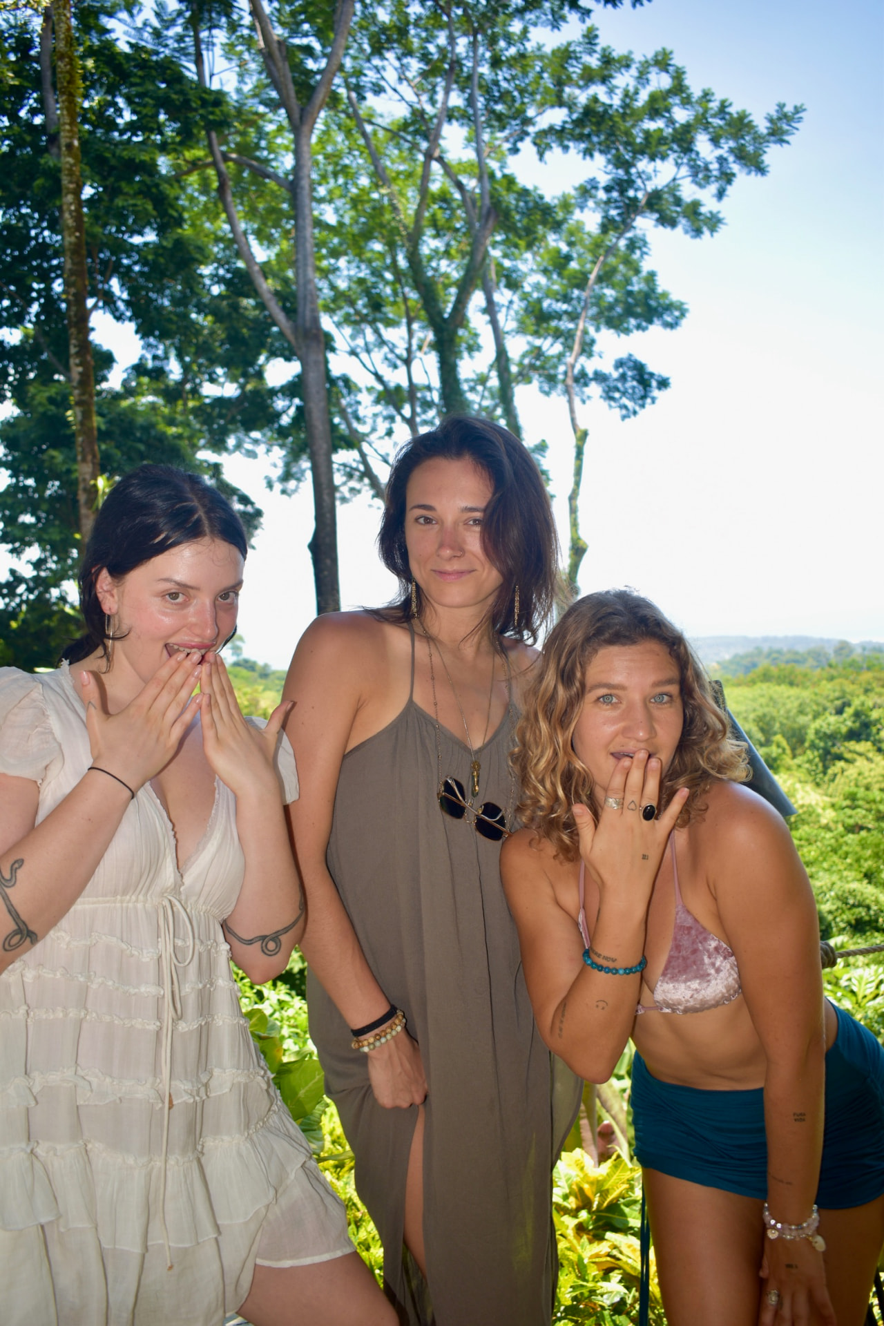 Three friends making playful faces in the jungle