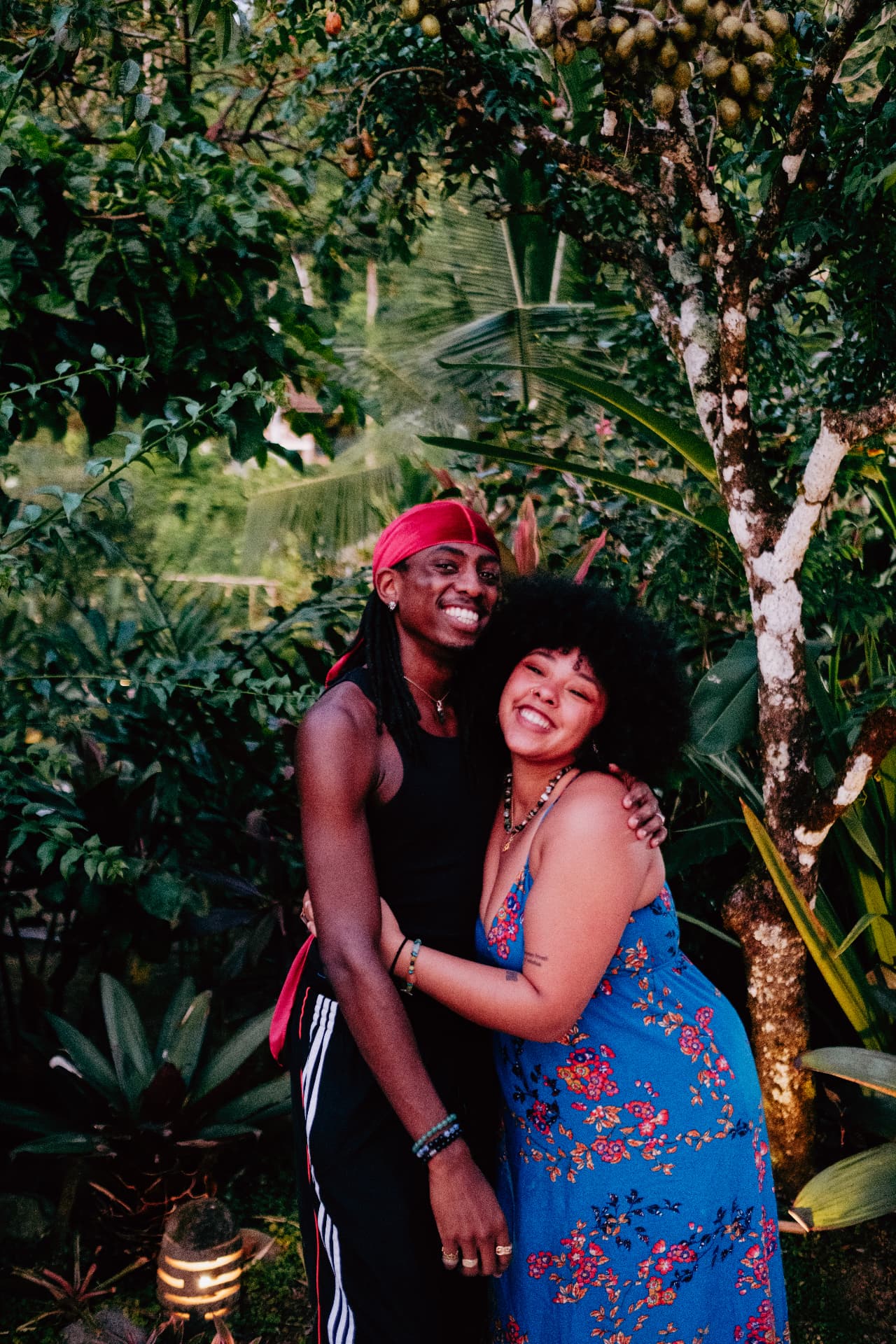 Two guests hugging and laughing in the jungle garden at golden hour